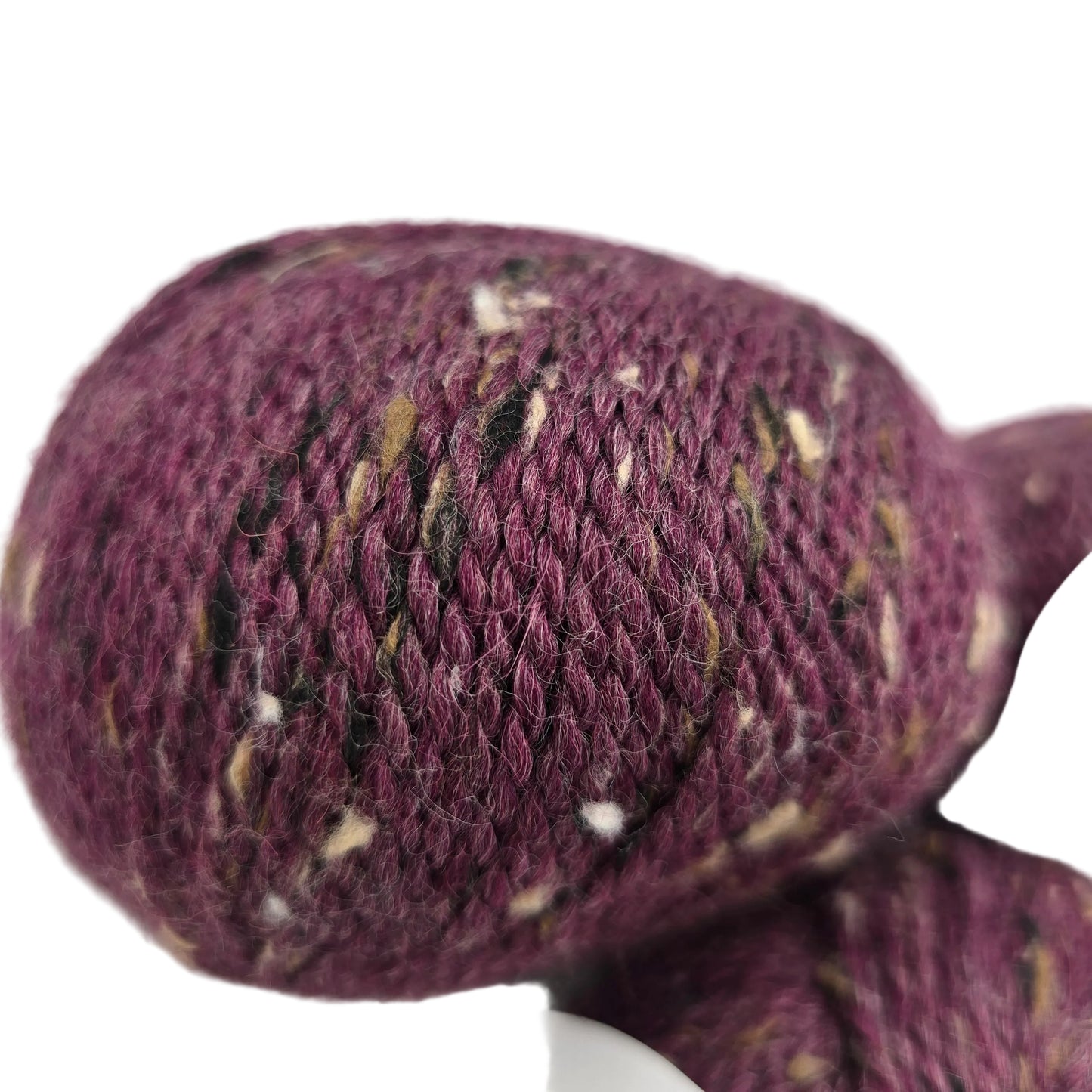 Close-up image of City Tweed DK by Knit Picks yarn in the color Plum Wine on a white background.