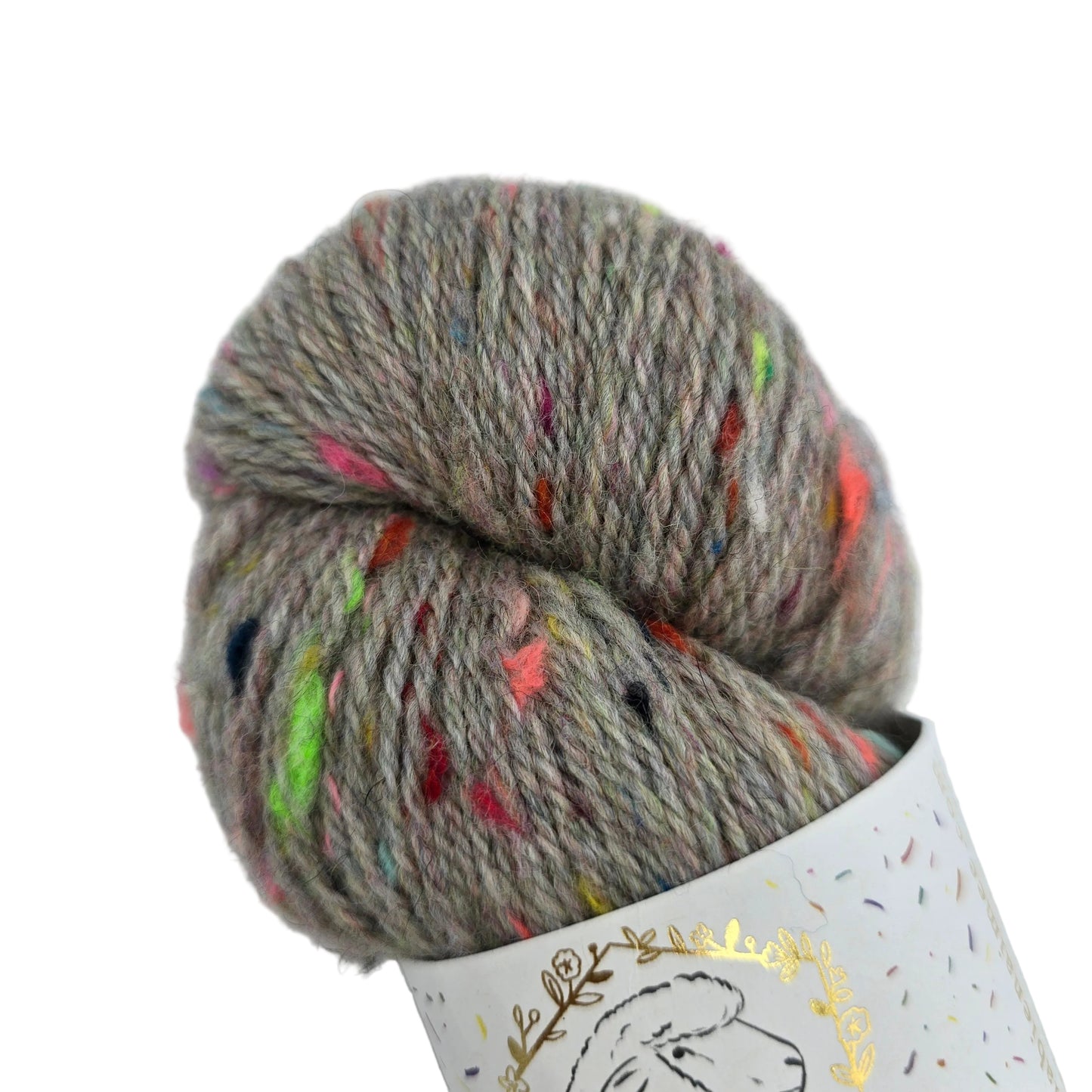 A skein of Corrie_Confetti_by_La_Bien_Aimee_in the color_Greybow_2_Fall_Winter_2021 variegated yarn in a heathered taupe-gray color with colorful flecks, partially wound on a white paper cone with a gold foil sheep outline.