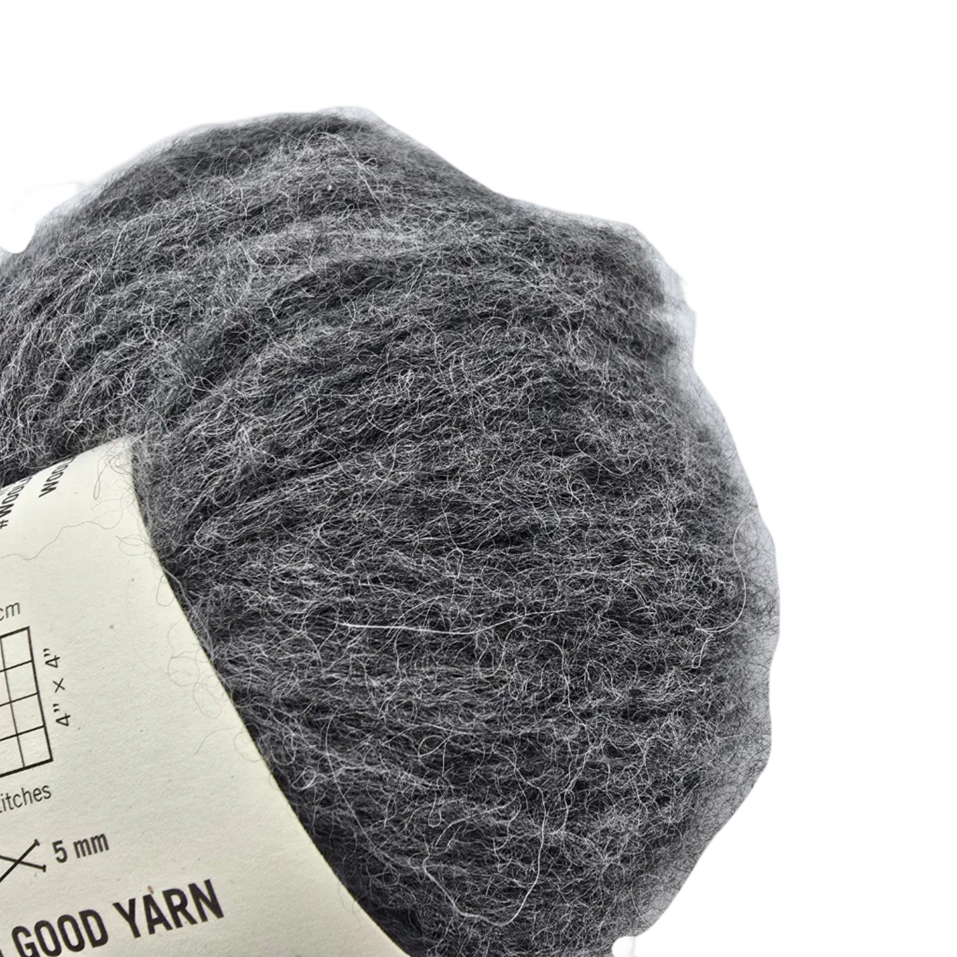 Close-up Image of a single ball of Feeling Good Yarn by Wool And The Gang in the color Silver Fox Grey with partial label visible on a white background.