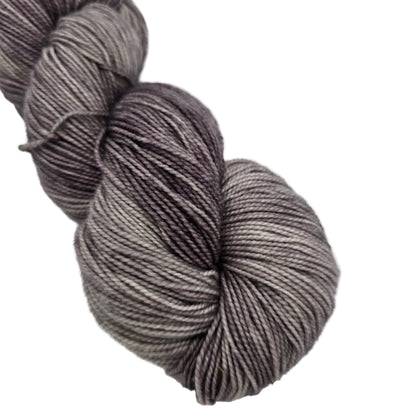 Close-up Image of a single skein of Hawthorne Fingering Weight Yarn by Knit Picks in the color Silverton Tonal Paint with label on a white background.