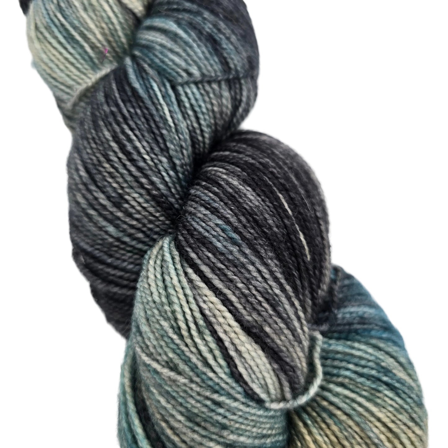Close-up image of a single skein of Hawthorne Fingering Weight Yarn by Knit Picks in the color Macadam on a white background.