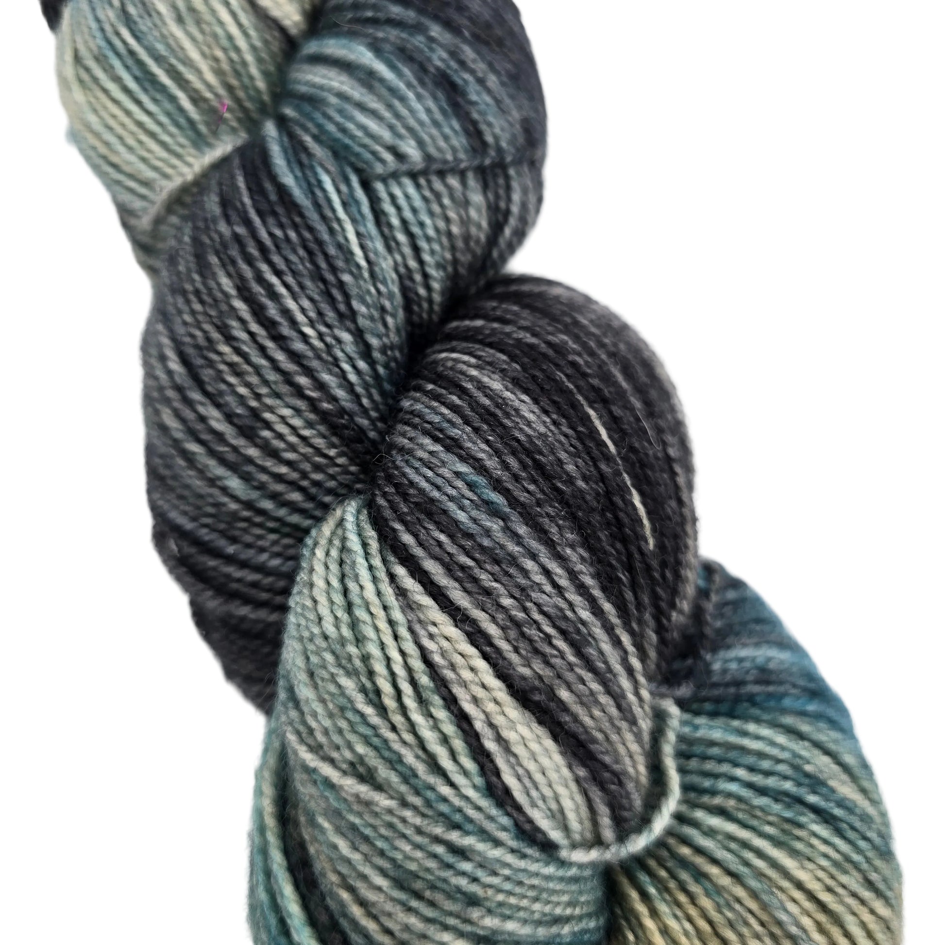 Close-up image of a single skein of Hawthorne Fingering Weight Yarn by Knit Picks in the color Macadam on a white background.
