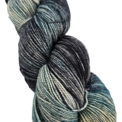 Close-up image of a single skein of Hawthorne Fingering Weight Yarn by Knit Picks in the color Macadam on a white background.