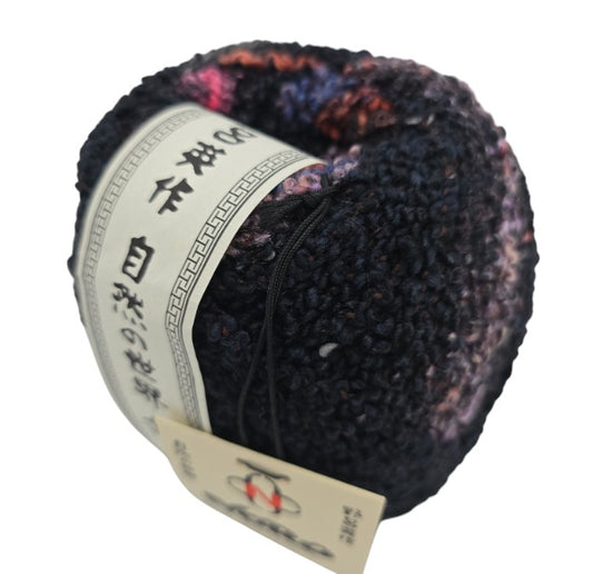 Close-up image of a single skein of Kanzashi by Noro - Color 16 Kasatsu yarn on a white background.