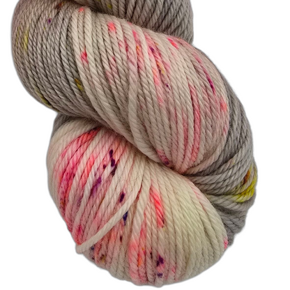 Close-up image of wool from the brand La Bien Aimee in the color Fiori (which is a mix of pink, grey and cream) on a white background.