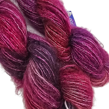 close-up Image of Two Skeins of Mohair yarn by Malabrigo in color Aniversario on a white background.,