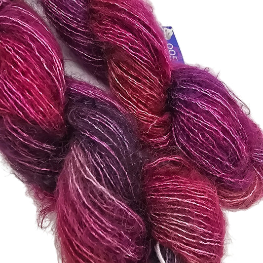 close-up Image of Two Skeins of Mohair yarn by Malabrigo in color Aniversario on a white background.,