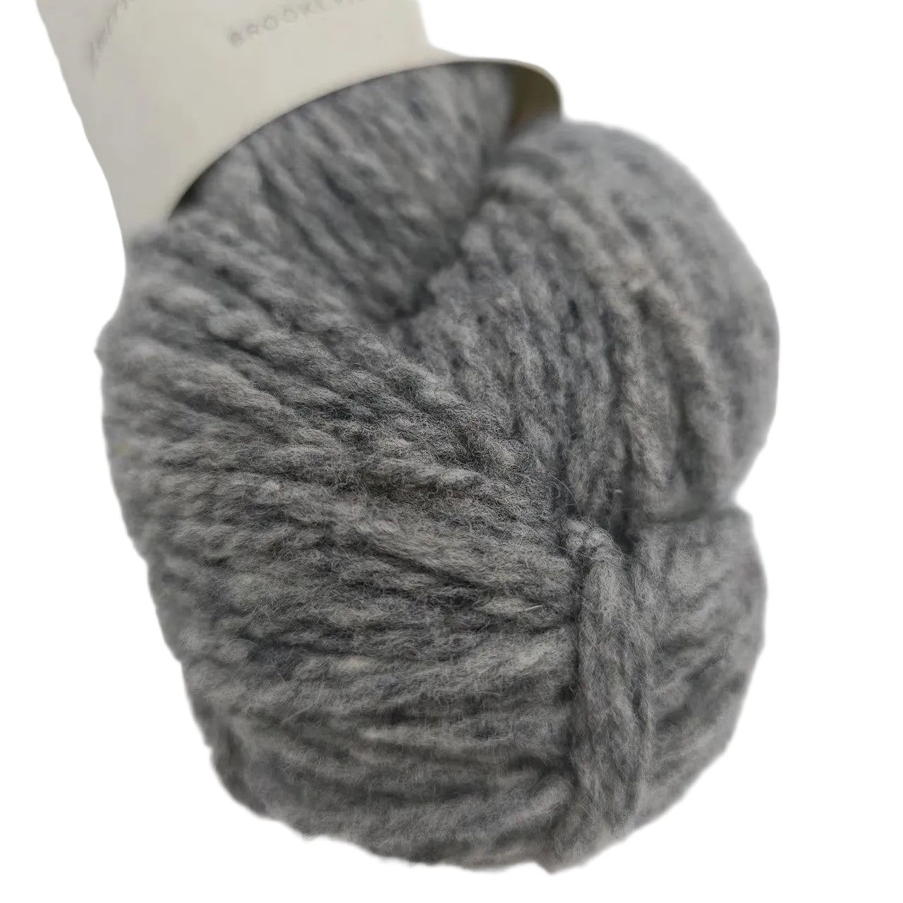 Close-up image of Shelter Yarn By Brooklyn Tweed in the color Sweatshirt with partial label on a white background.