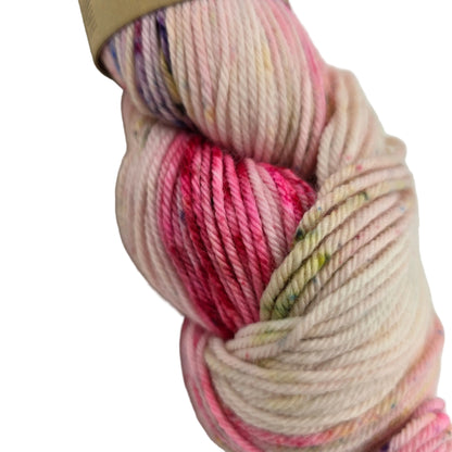 Close-up Image of a single skein of Simply Spectacular DK yarn by Emma's Yarn in color May '22 with partial label on a white background.