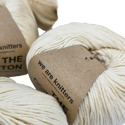 Close-up image of The Cotton Yarn by We Are Knitters in Natural with labels on a white background.
