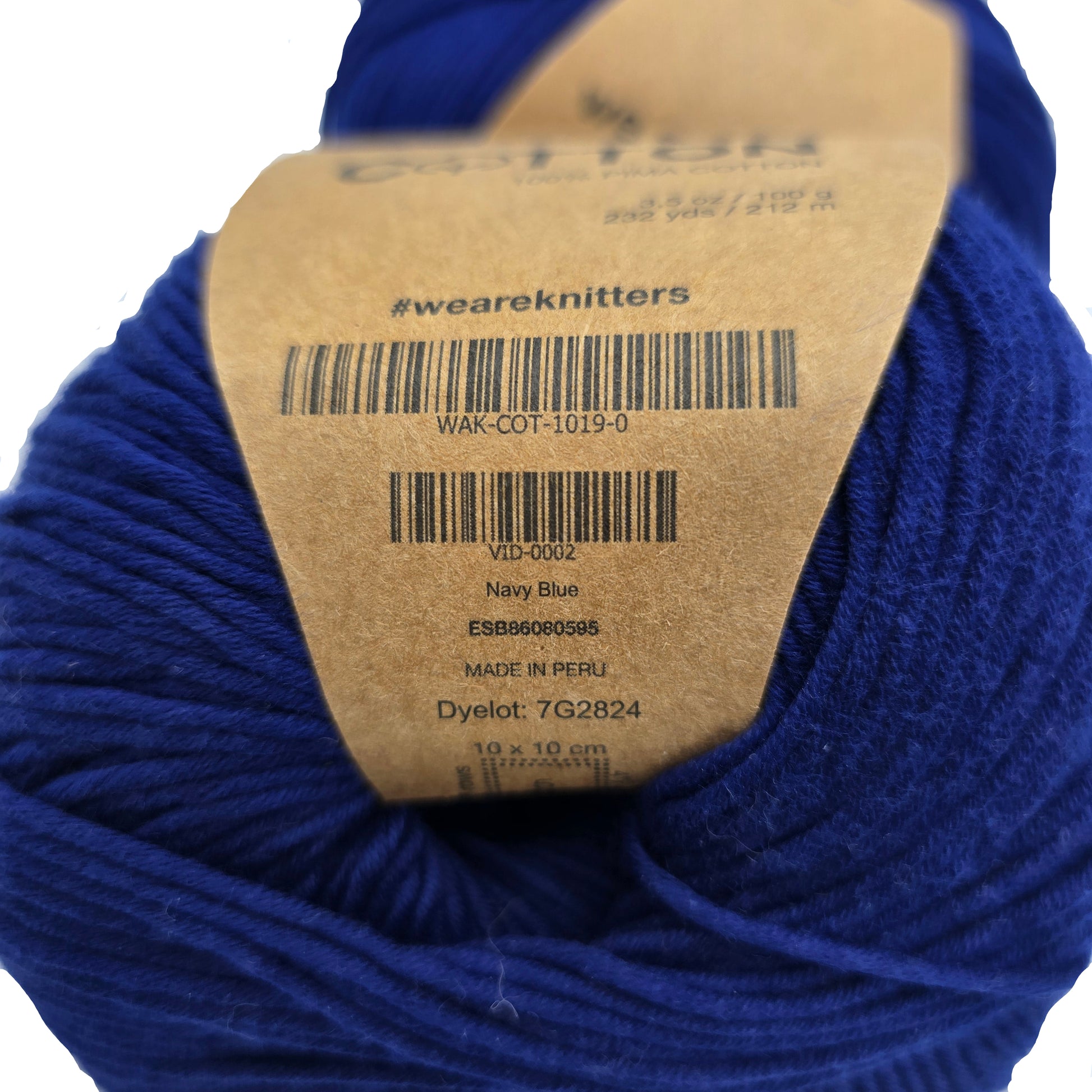 Close-up image of The Cotton Yarn by We Are Knitters in Navy Blue with label on a white background.