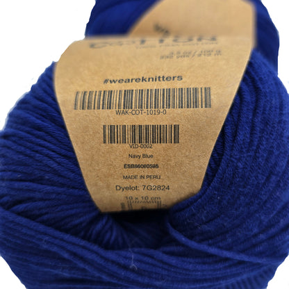 Close-up image of The Cotton Yarn by We Are Knitters in Navy Blue with label on a white background.