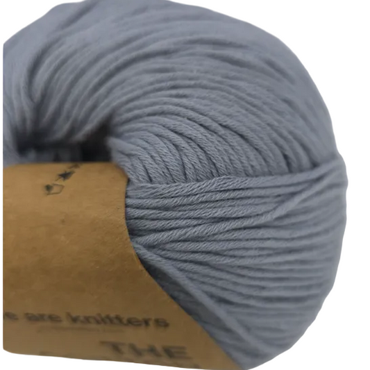 close-up image of The Cotton yarn by We Are Knitters in Color 5146 Grey with partial label on a white background.