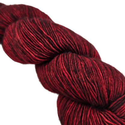 Close-up image of Tosh Merino Light yarn by Madelinetosh in the color Tart on a white background.