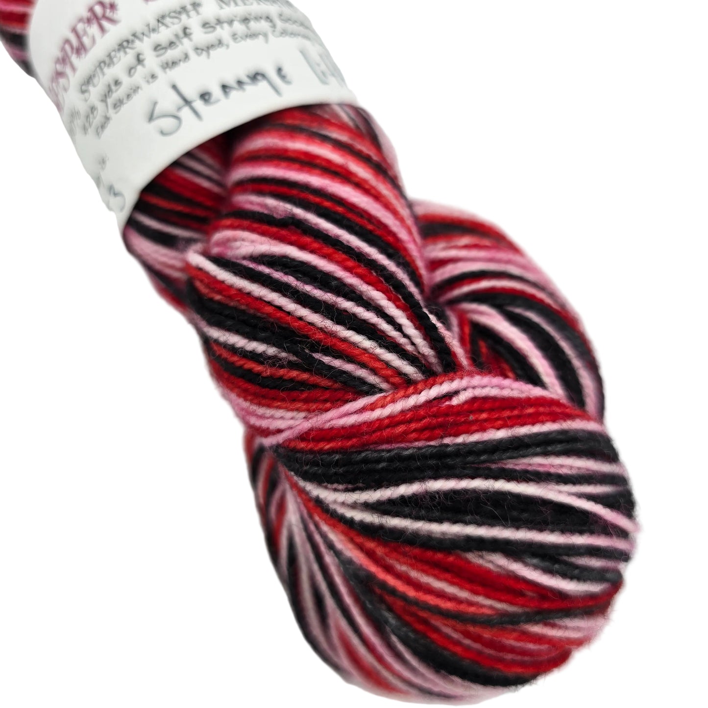 Close-up image of Vesper Sock Yarn by Knitterly Things in the color Strange Little Mama with partial label on a white background.