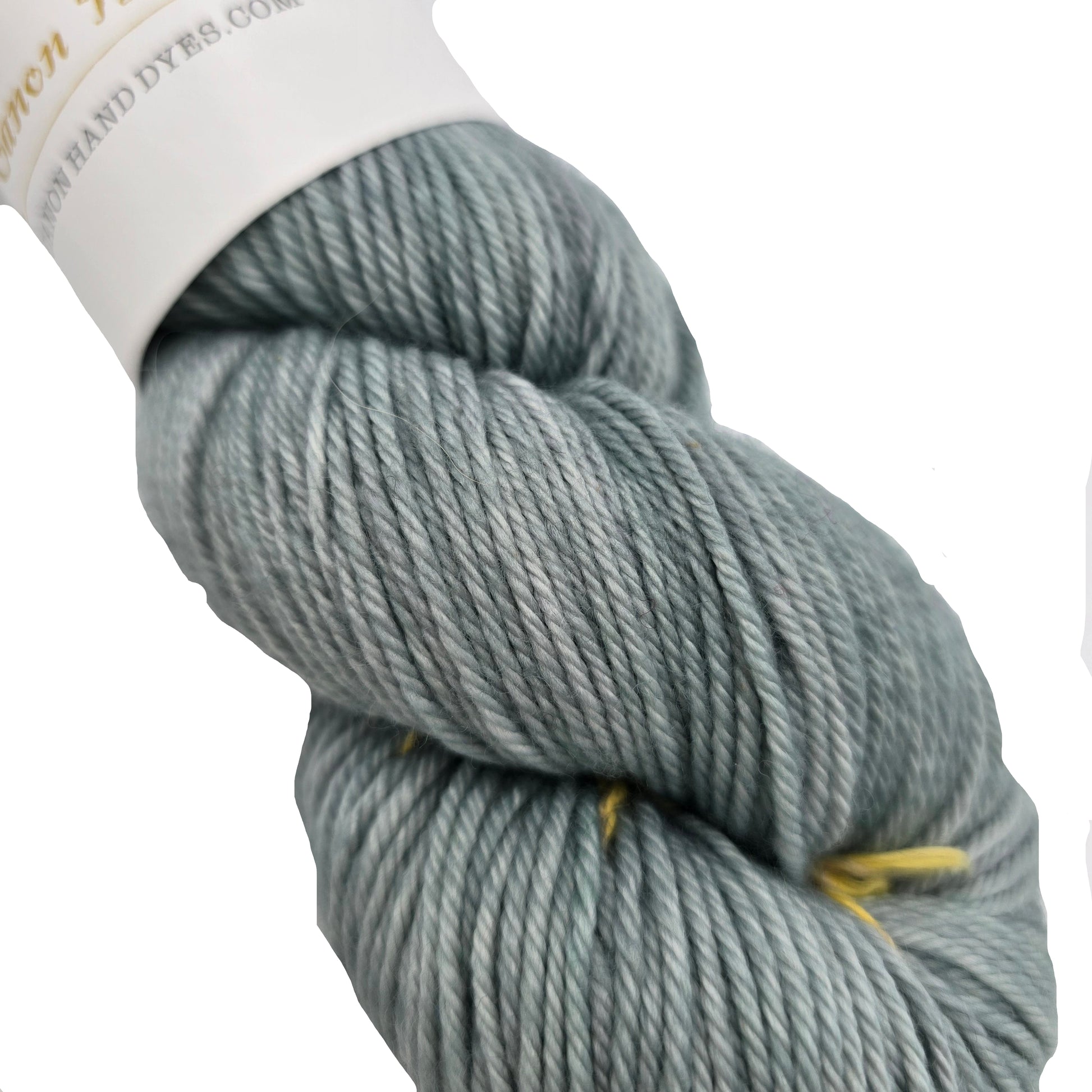 Close-up Image of a single skin of William DK Merino Yarn By Canon Hand Dyed in the color Meg Little Women with a partial label on a white background.