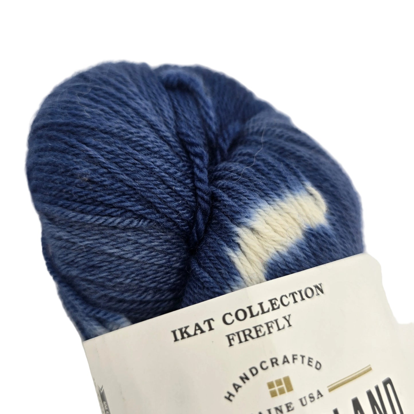 Close-up image of Ikat Collection Firefly Yarn by Swans Island in the color Firefly Prussian Blue IFF203 with a partial label on a white background.