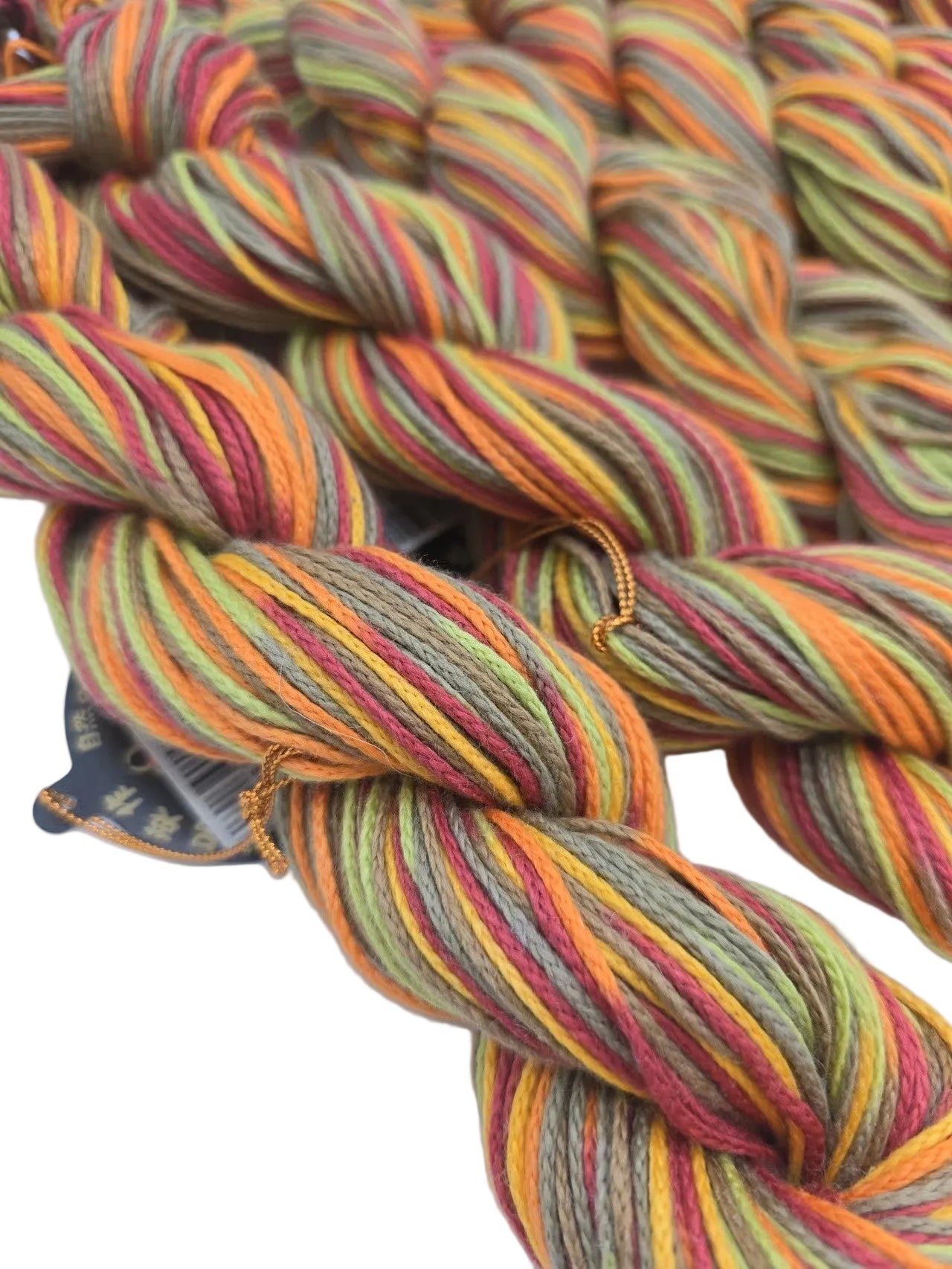 Close-up image of Lily Multi  Yarn by Noro - Color 119 Fruit Salad with partial label on a white background.