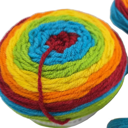 Close-up of caron cake of yarn in the color rainbow sprinkles with label on a white background.