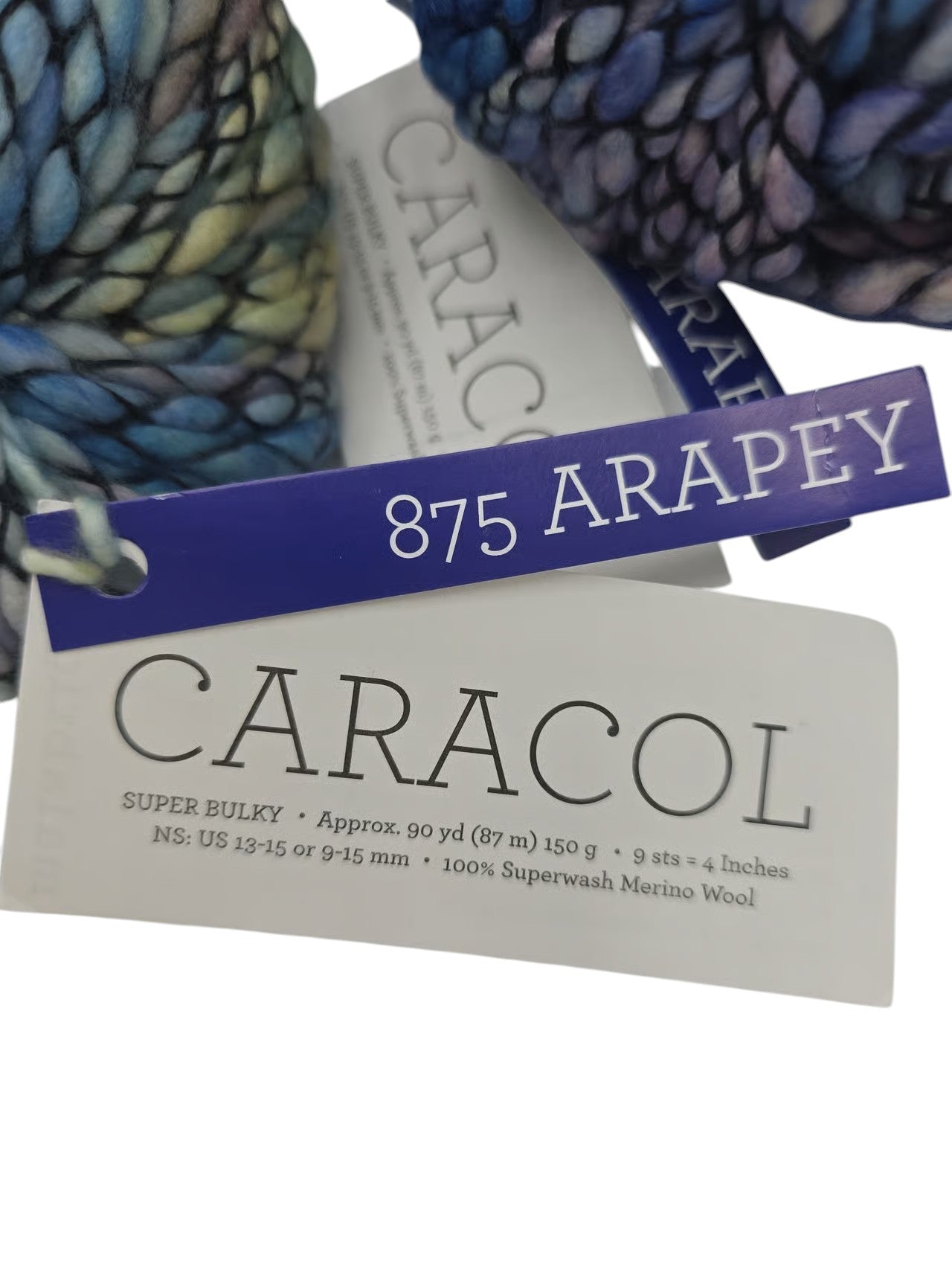 Close-up of the label on Multicolored Skeins of Caracol by Malabrigo Super Bulky Superwash Merino Wool yarn on a white background.