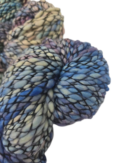 Close-up image of texture of Multicolored Skeins of Caracol by Malabrigo Bulky Merino Wool yarn on a white background