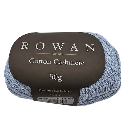 Close-up of the label on a ball of Cotton Cashmere yarn by Rowan in color Morning sky on a white background.