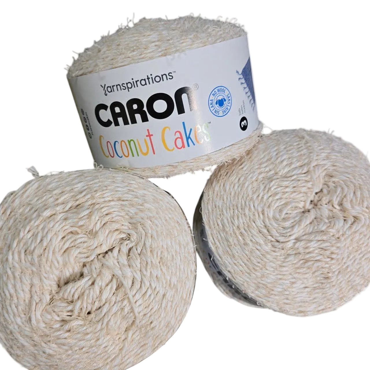 Image of 3 cakes of Coconut Cakes by Caron Yarn in the color Marshmallow with label on a white background.