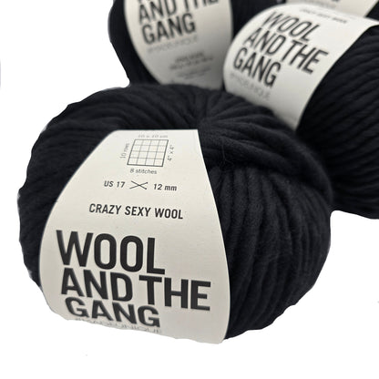 Image of several balls of Crazy Sexy Wool yarn by Wool And The Gang in the color Space Black with labels on a white  background.
