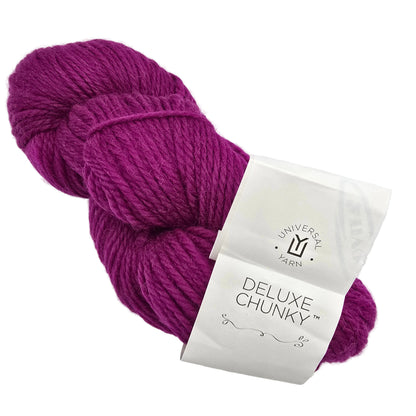 A skein of Deluxe Chunky yarn by Universal Yarn in Cerise a magenta-purple with label on a white background.