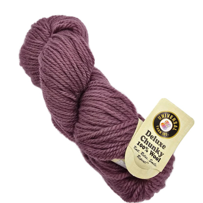 A skein of Deluxe Chunky 100% Wool yarn in Tulipwood a dusty mauve-purple color, with its original cream-colored paper label attached, set against a plain white background.