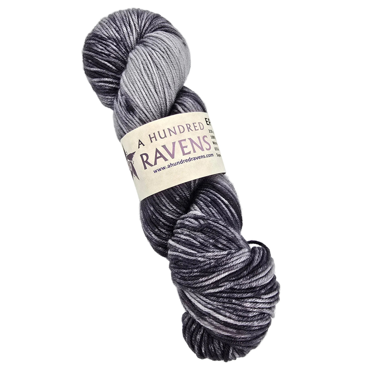 A skein of variegated yarn in shades of charcoal gray, black, and light gray, wrapped with a paper label that reads 'A HUNDRED RAVENS' on a white background.