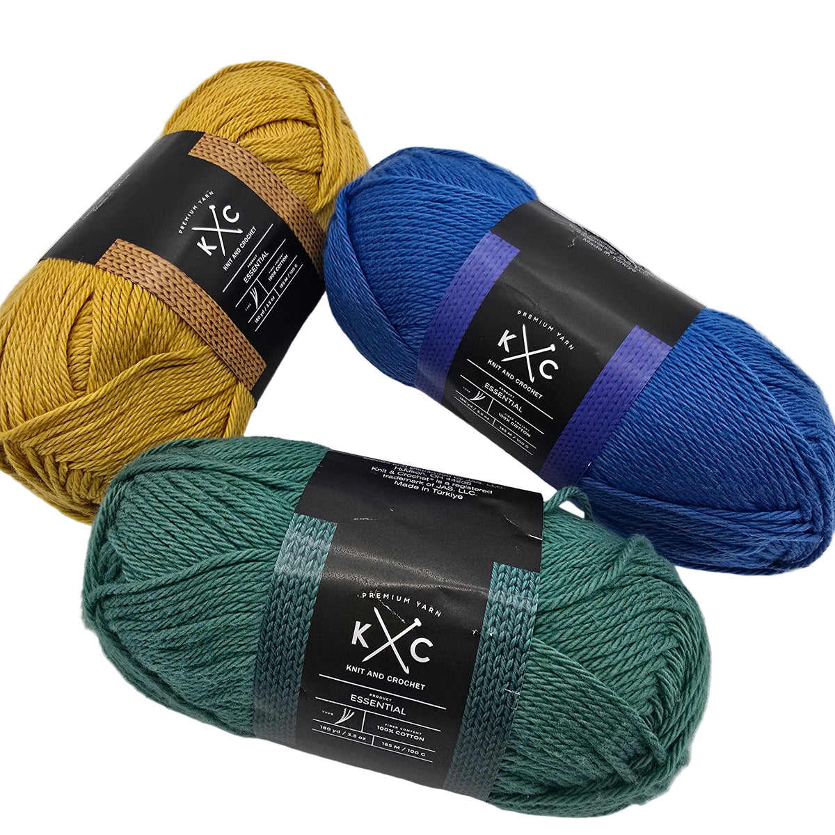Image of three skeins of Essential Cotton Yarn buy K+C one each in blue, green, and yellow with labels on a white background.