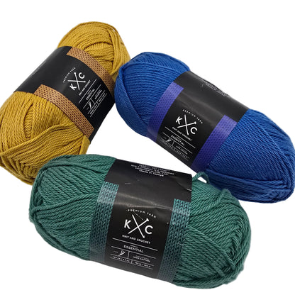 Image of three skeins of Essential Cotton Yarn buy K+C one each in blue, green, and yellow with labels on a white background.