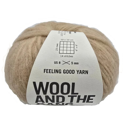 Image of a single ball of Feeling Good Yarn by Wool And The Gang in the color Blonde Beige with label on a white background.