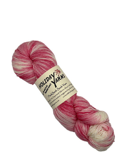Single skein of FlockSock Sock Yarn by Holiday Yarns  in color Pretty in Pink on a white background with label. 