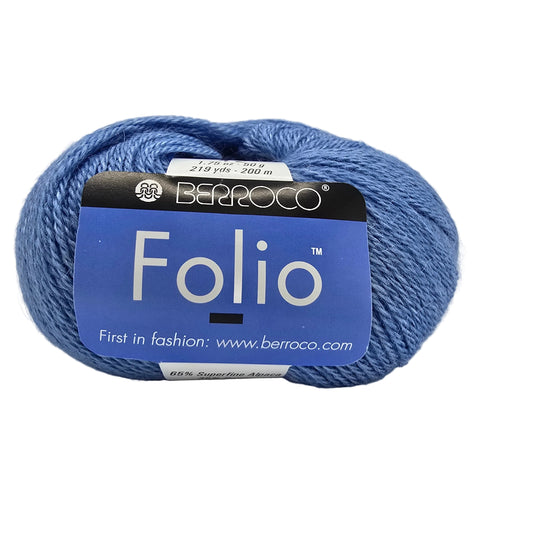 A skein of blue Berroco Folio yarn with its blue and black paper label, photographed on a white background.