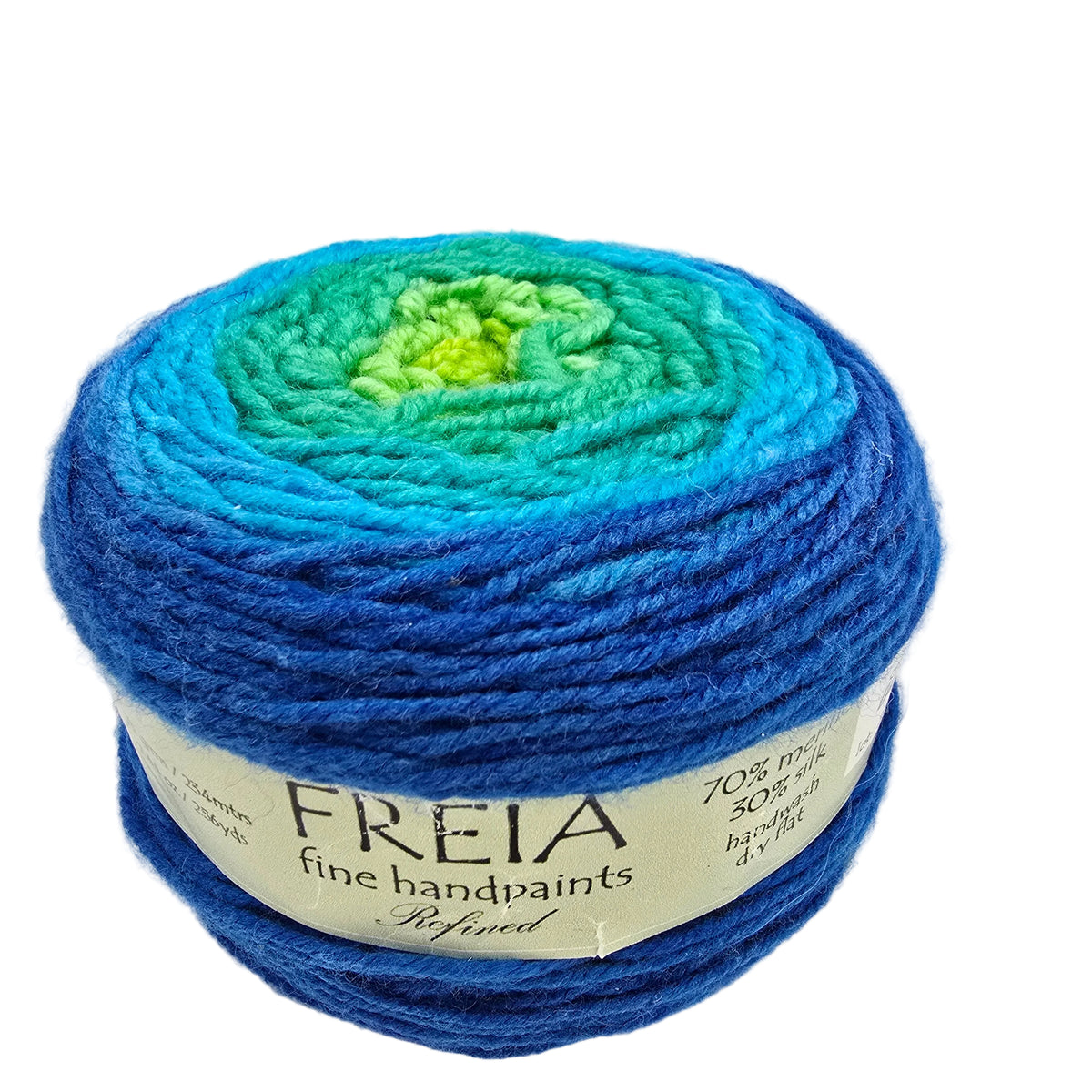 A ball of Freia Fine Handpaints yarn with a gradient of colors transitioning from bright lime green in the center, through teal and aqua, to deep royal blue. The yarn is wrapped in a white paper label with the brand name 'FREIA' clearly visible, set against a plain white background.