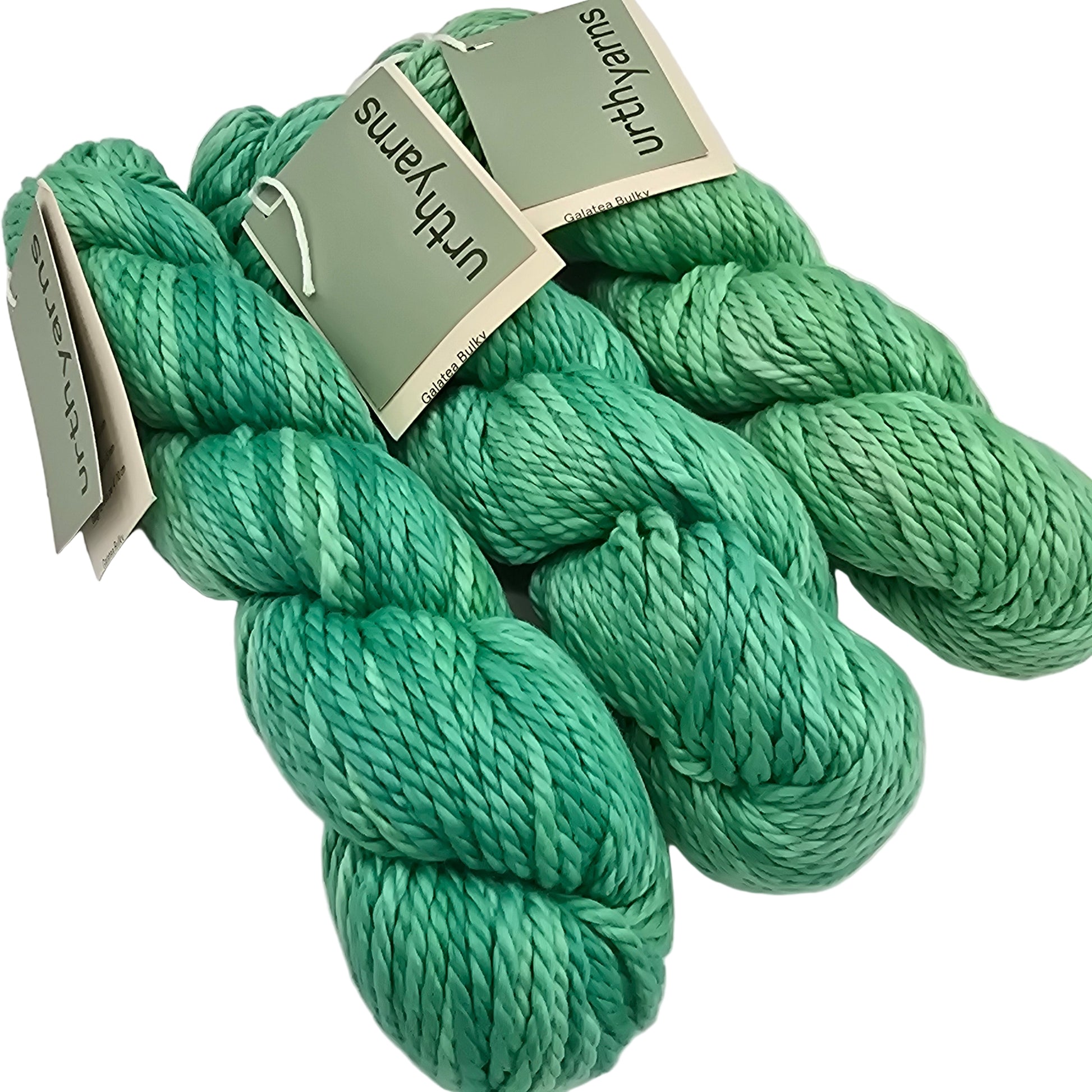 Image of three skeins of bulky, cotton yarn by brand Urth Yarns in the color Galatea (which is a bright tonal green) with labels on a white background.