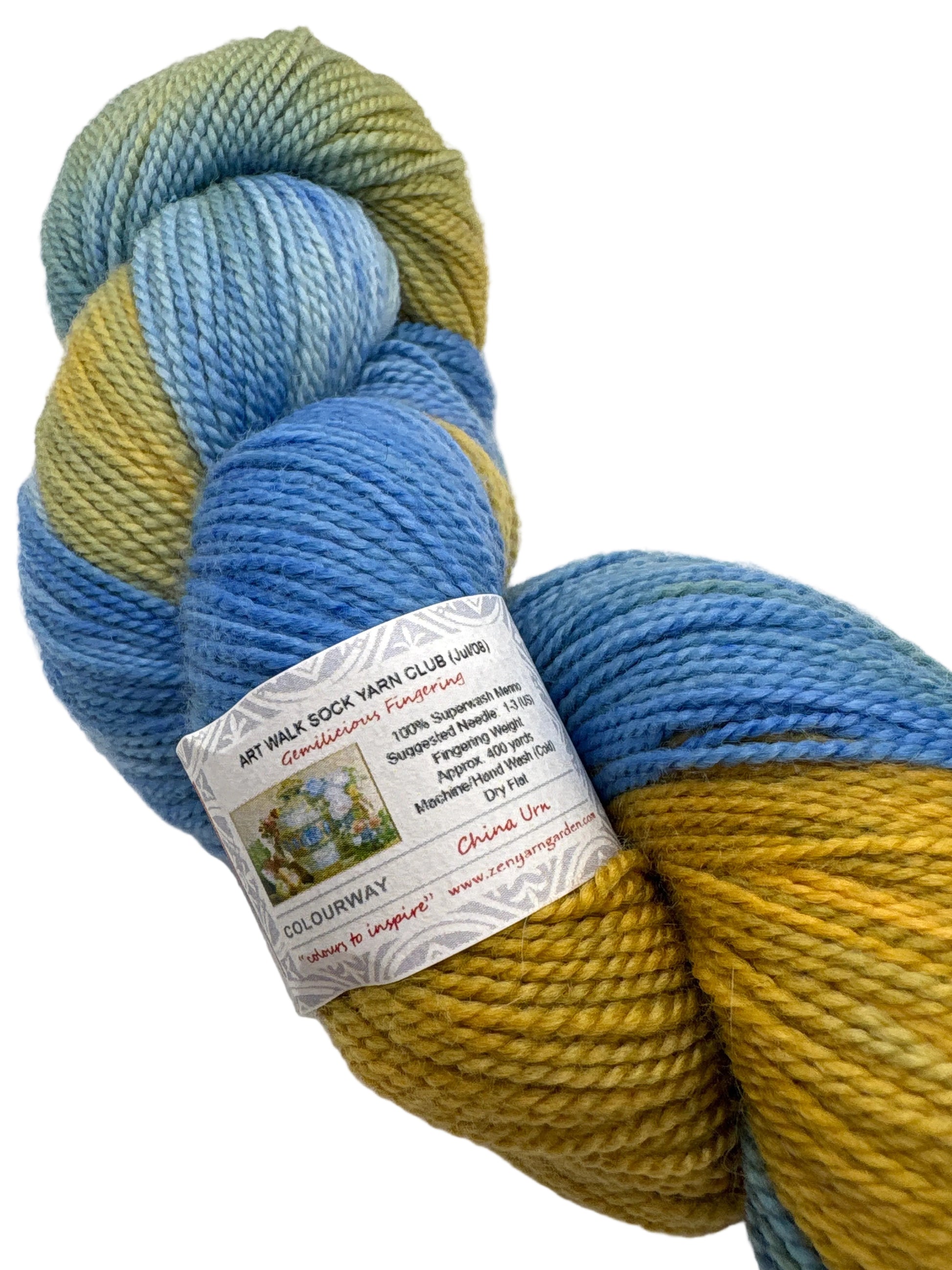 Skein of Yellow and blue Gemilicious fingering weight yarn with view of details on label on white background.