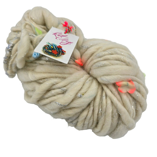 Image o f a single skein of Gypsy Garland Yarn by Knit Collage in the color Stardust Garden with label on a white background.