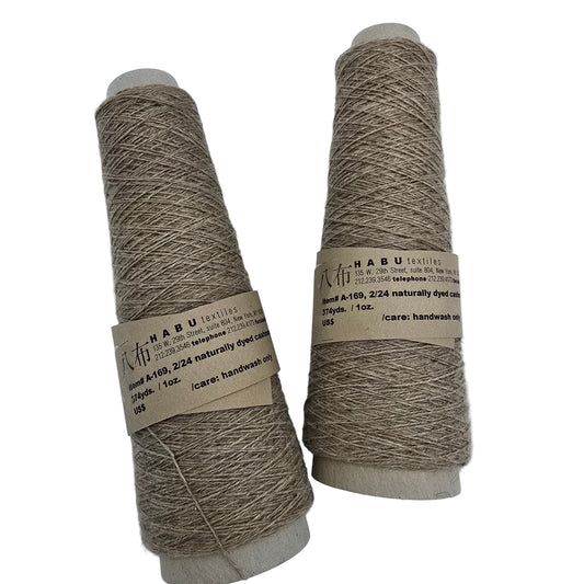 Two spools of Habu Textiles brown yarn with labels on a white background
