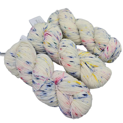 Image of three hanks of Hawthorne by Knit Picks yarn in the color Confetti Speckle with labels on a  white background.