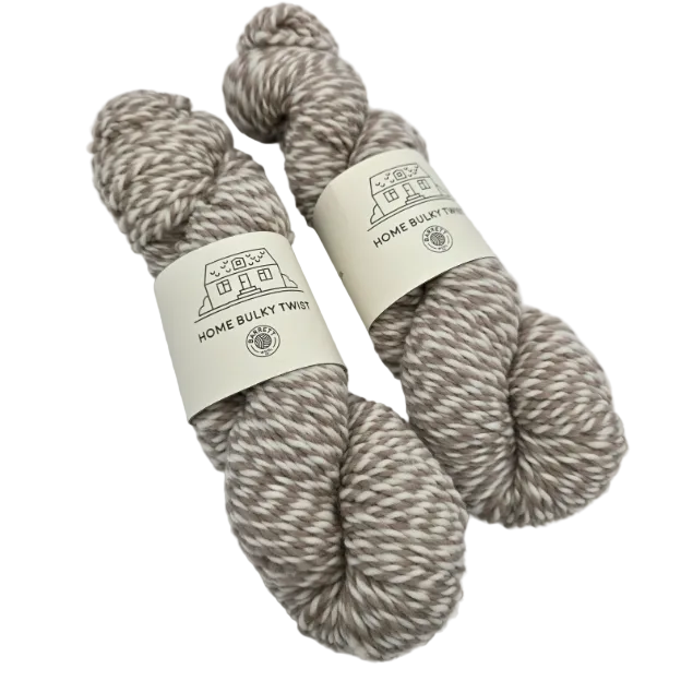 Two skeins of Home_Bulky_Twist_Yarn-by_Barrett_Wool_Co. in the color Tattersall_Twist a variegated wool yarn with labels on a white background.