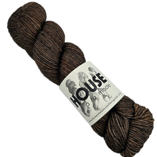 Image of a single skein of House DK Yarn by House of a La Mode in the color Moto: The Semi Smokey Collection with label on a white background.