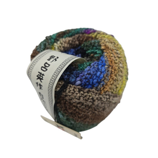 Multicolored Kanzashi by Noro brand yarn ball with a label on a white background