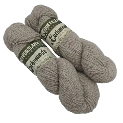 Two Skeins of Kathmandu Aran 100 yarn by Queensland Collection in color 32 Beige with labels on a white background.