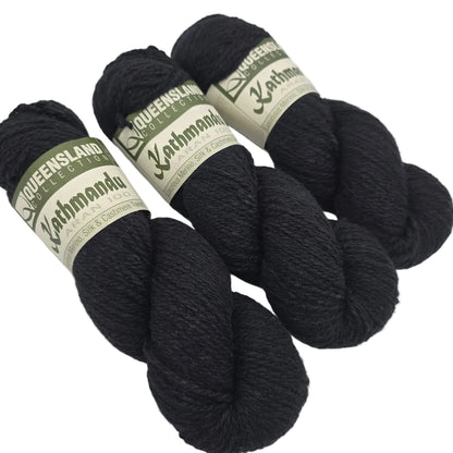 Image of three skeins of Kathmandu_Aran_100_yarn by_Queensland_Collection_-in_Color_3 Black with labels on a white background.