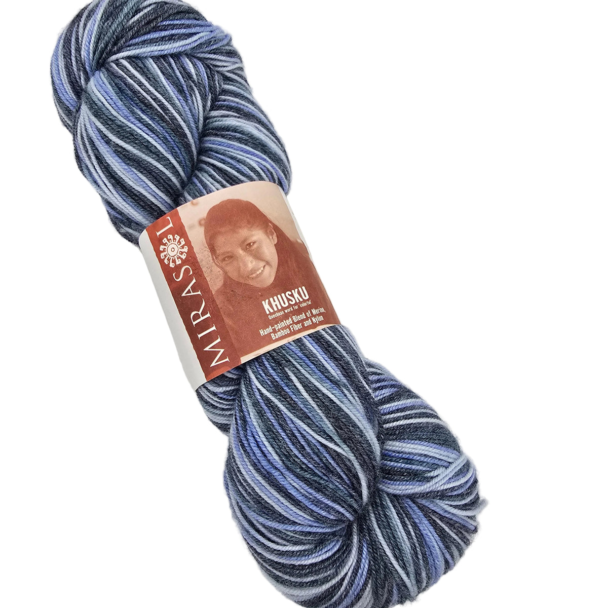 A skein of Mirasol Khusku yarn featuring a variegated pattern of navy, blue, and white stripes, with a brown paper label showing a portrait of a woman.