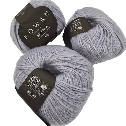 Three skeins of gray yarn with Rowan labels on a white background