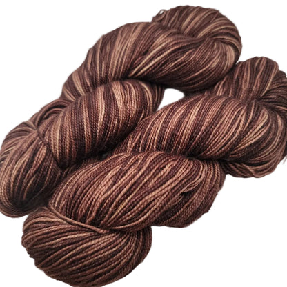 Image of two skeins of Knit Picks Hawthorn Fingering Yarn in the color Faun Kettle Dye on a white background.